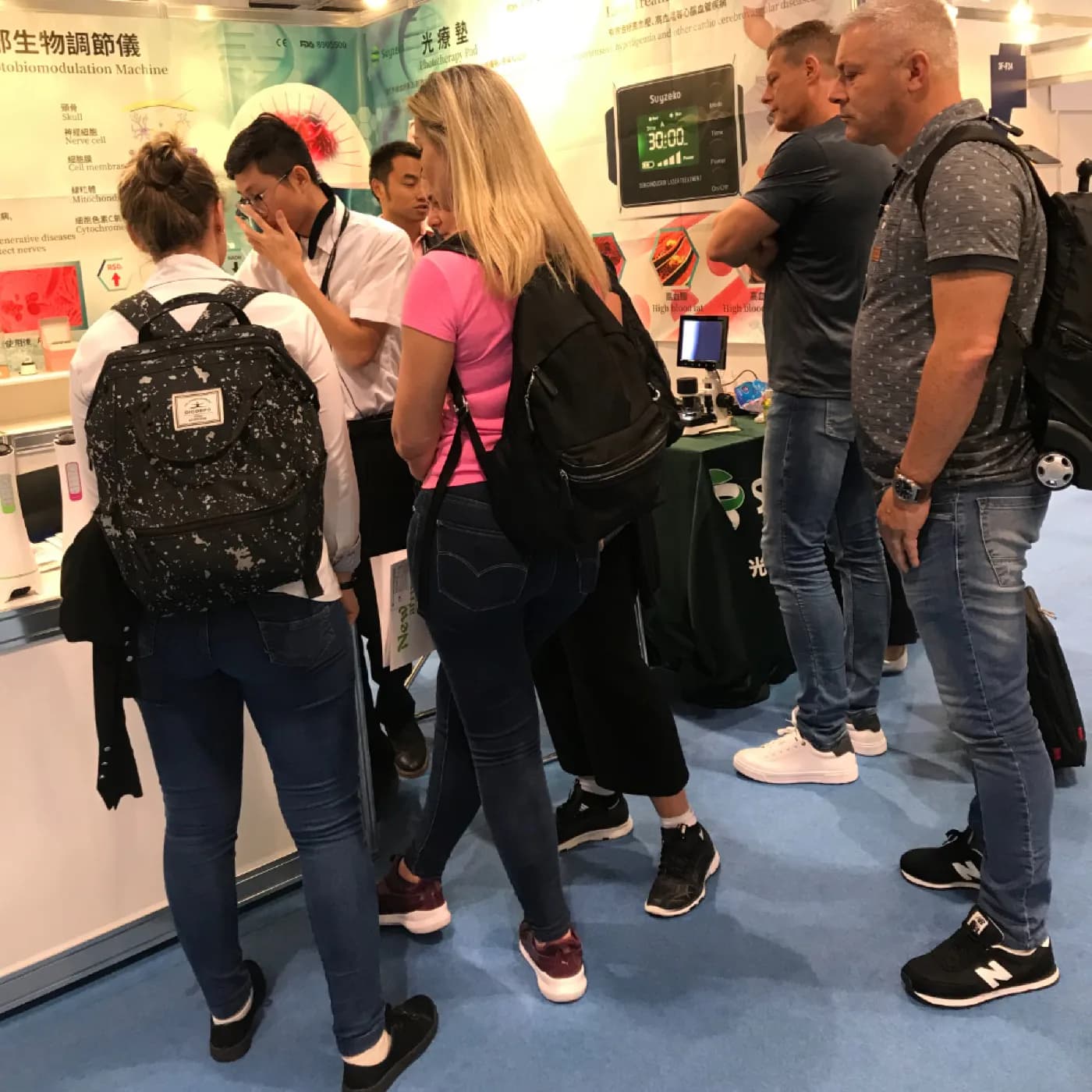 Y-Rising staff demonstrating wellness equipment to visitors at an international trade show